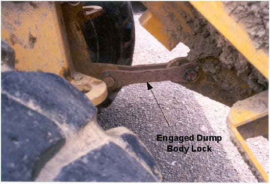 Dump body lock when dump body is in the raised position and the dump body lock has been engaged.