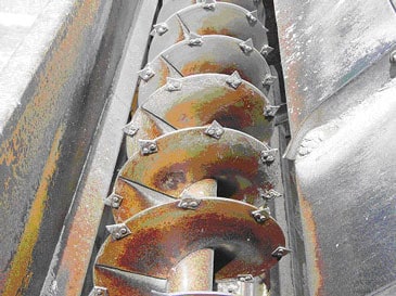 Auger portion of the feed mixer-grinder. Note the razor-blades mounted on the auger to facilitate cutting/grinding.