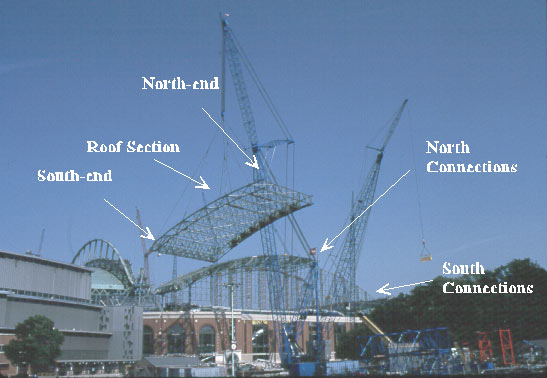 Heavy-lift crane with roof section before moving over stadium.