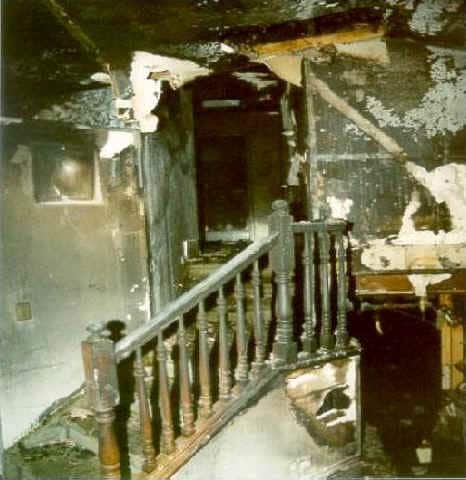 Front page photo: Interior photo of the burned-out stairwell of the house.