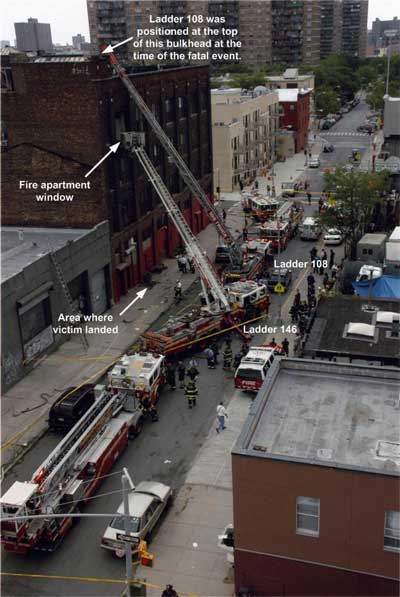 Ladder trucks with ladders extended on the apartment building