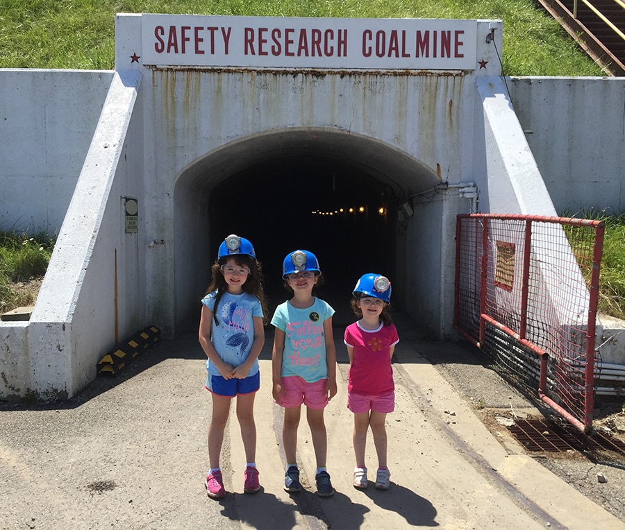 A photo of Steve Sawyer's daughters in front of a mine opening
