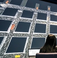 Photo of a researcher studying a virtual reality model of a mine ventilation system on a large screen.