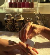 Hand shot of a manicurist filing a customer’s fingernails