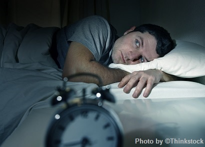 Man waking up to alarm clcok in the morning