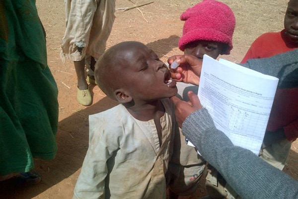 aa child taking oral polio vaccine
