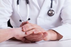 Doctor's hands consoling patient's hands
