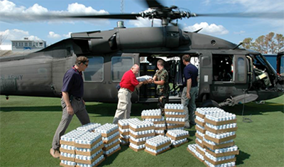 Photo: Individuals loading supplies into a helicopter.