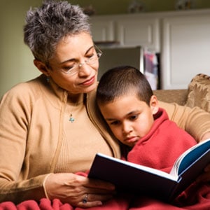 A grandmother reading to her sick grandson