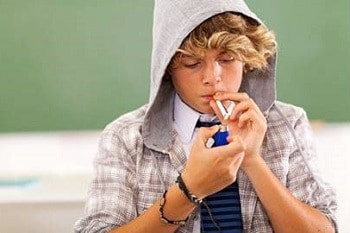 Image of a teen boy smoking a cigarette