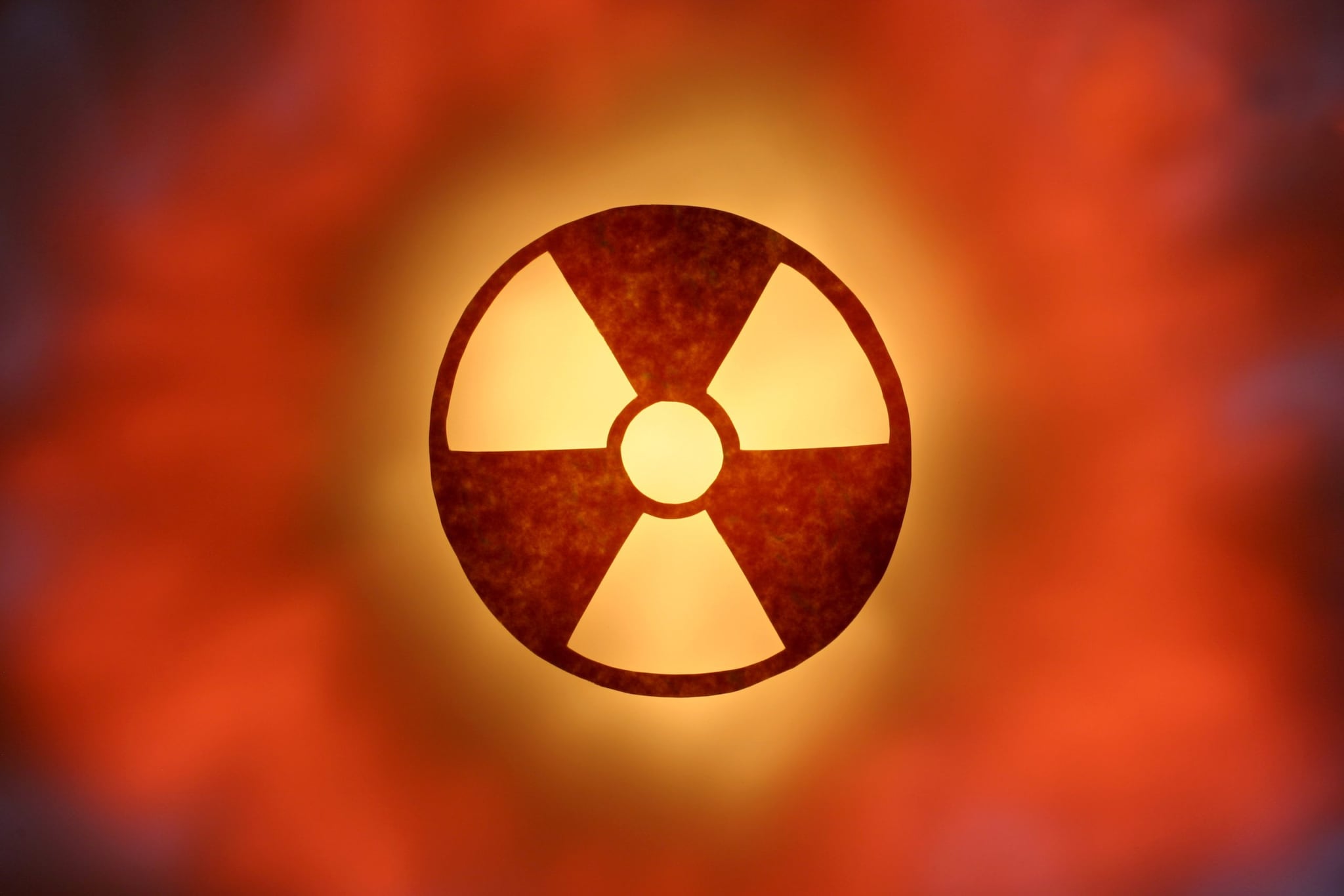Red-orange colored glowing radioactive symbol