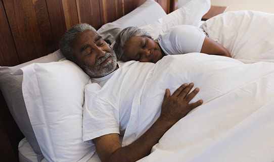 older couple sleeping in bed