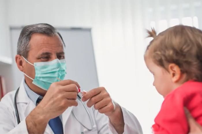 Foto de un médico vacunando a una niña contra la influenza