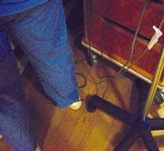 Pie de persona cerca de cables enmarañados en el piso