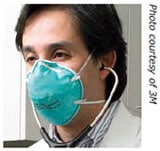 Trabajador de la salud con un estetoscopio en los oídos, usando un respirador con mascarilla de filtrado.