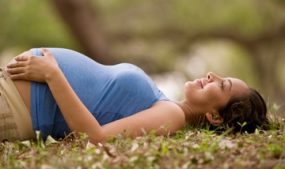 Pregnant woman lying on the grass