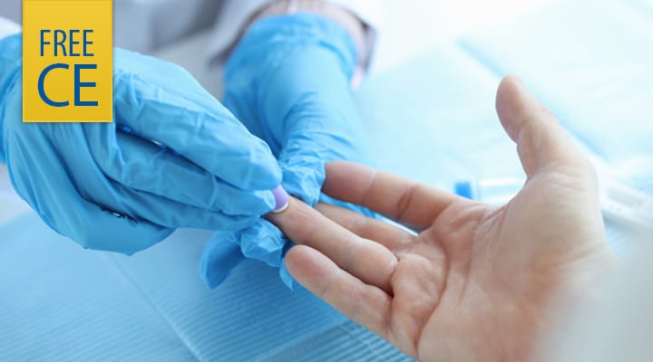Lab technician in gloves using finger prick on patient