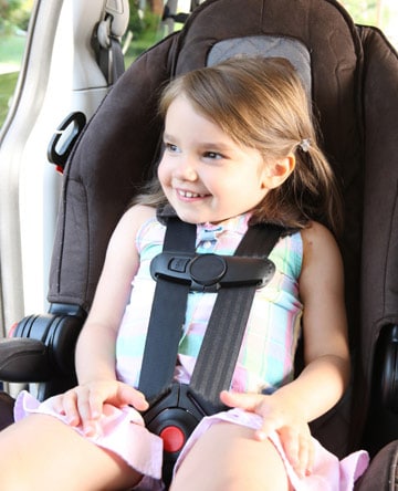 A young girl buckeld in a child seat