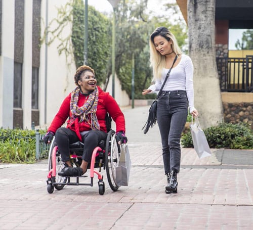 A woman in  a wheelchair talking to a friend