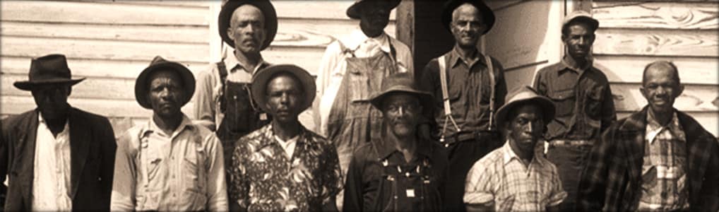 A sepia photograph of a group of African American men in an outdoor setting