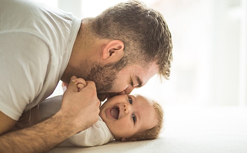 Father kissing happy baby