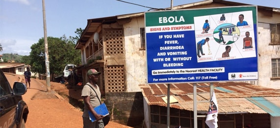 Man walking by Ebola Outbreak Poster
