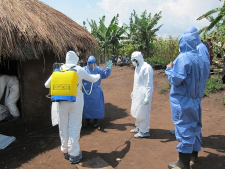 Health care workers dressed in protective clothing in an African village