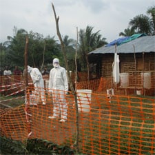 Health staff dressed in protective clothing constructing a perimeter for the isolation ward.