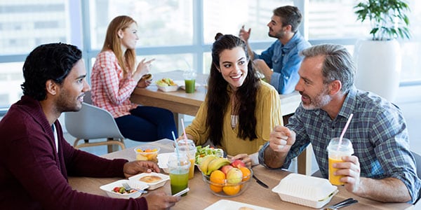 Multigenerations in workplace enjoying healthy lunch together