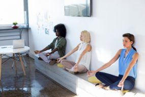 Female employees doing yoga at work