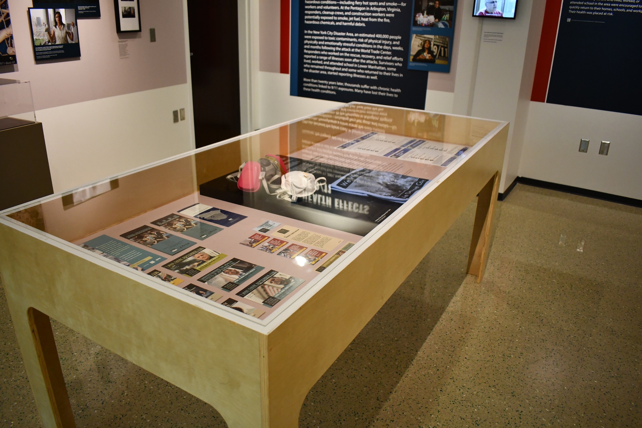 A glass case featuring information and artifacts from the Health Effects of 9/11 Exhibition.