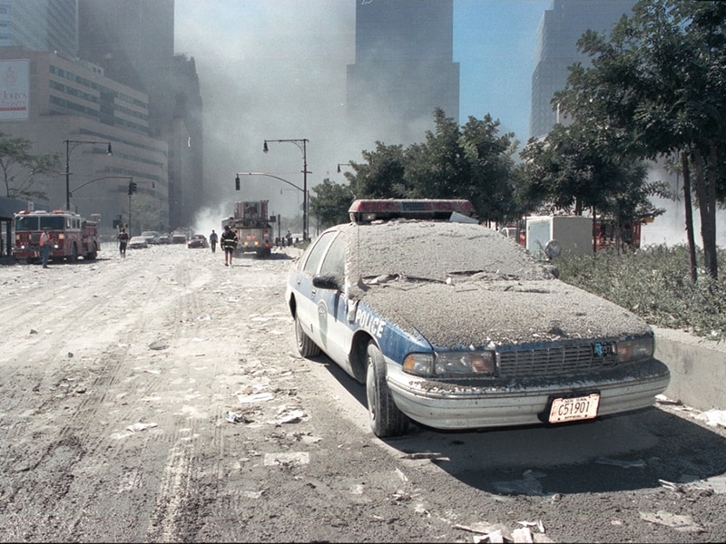 Photo of police vehicle on street, covered in a thick layer of dust from the fallen WTC buildings