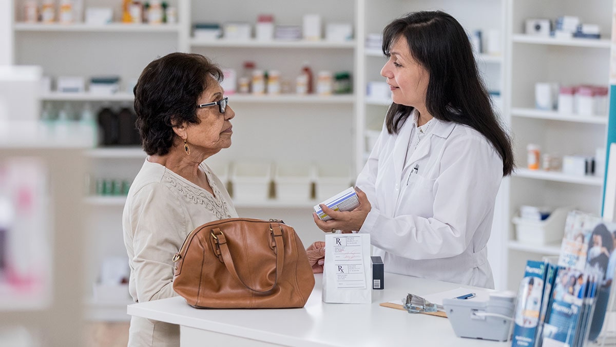 woman pharmacist talking to an older woman