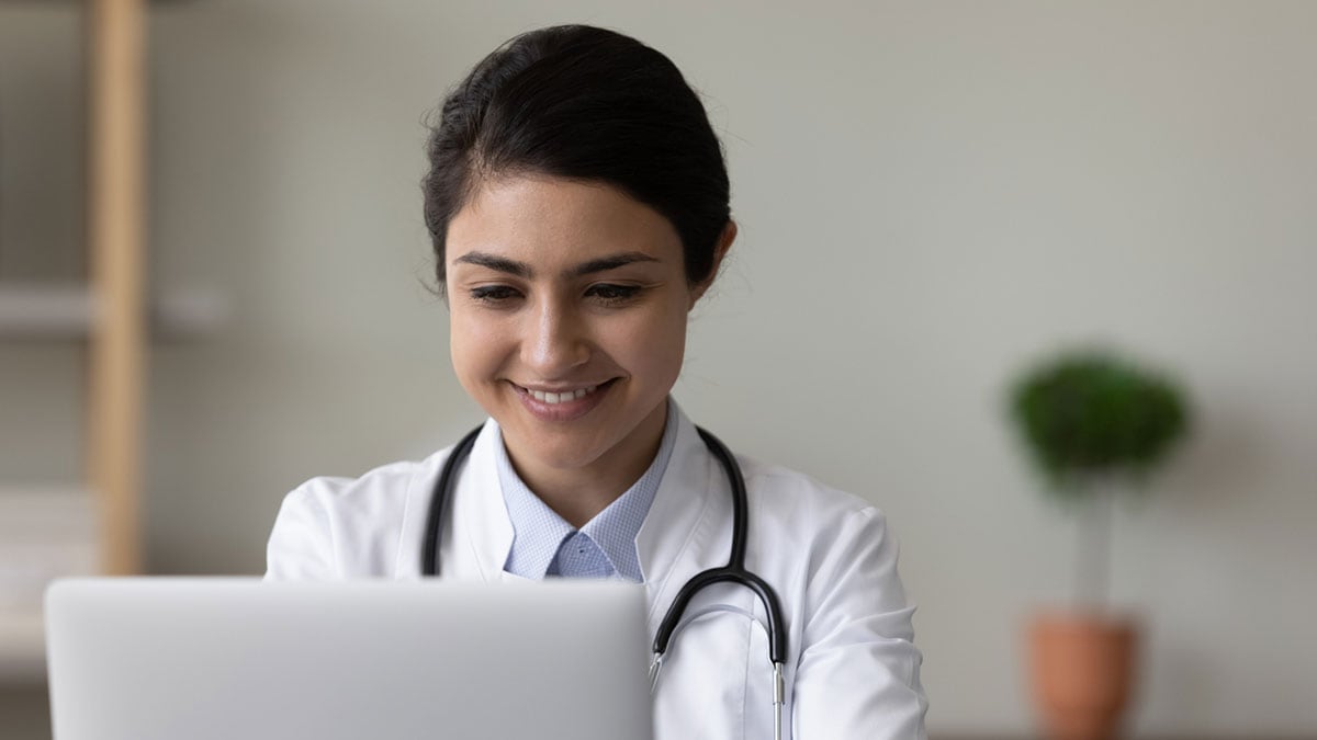 Female healthcare provider looking at laptop