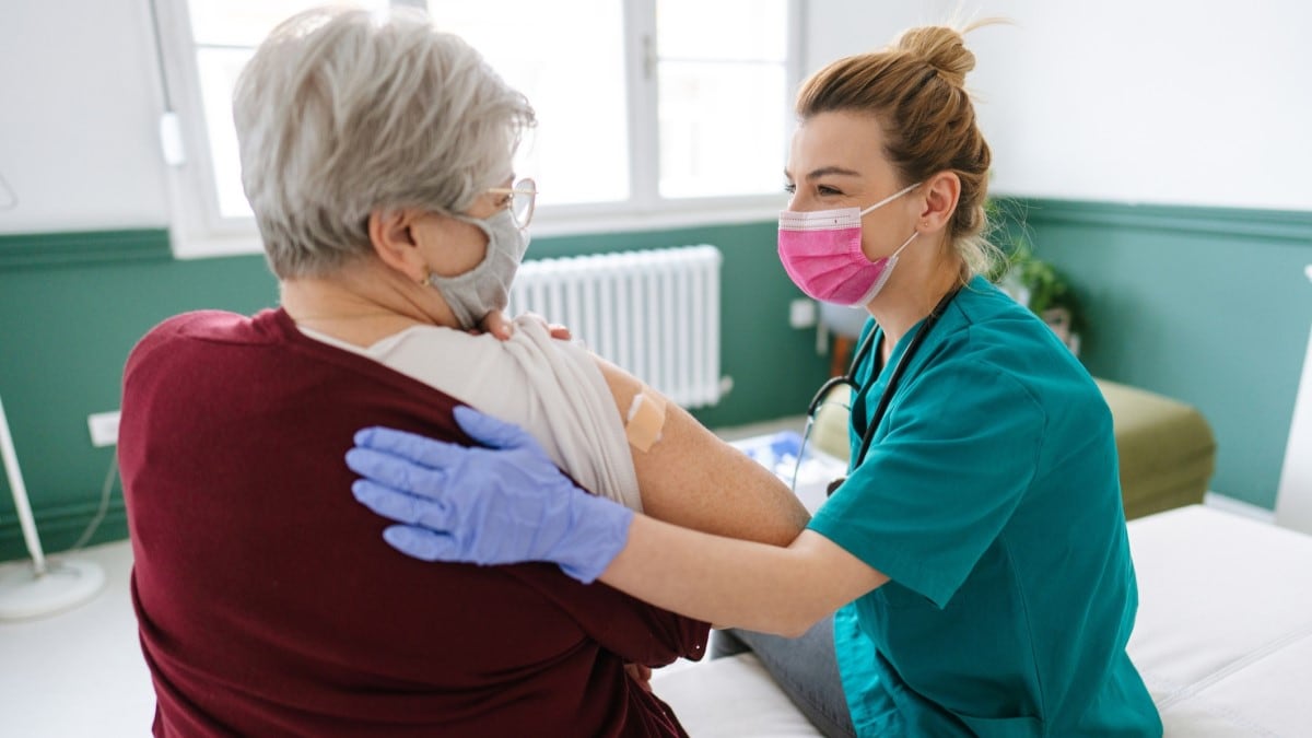 Foto de una enfermera dándole la vacuna contra la influenza a una mujer