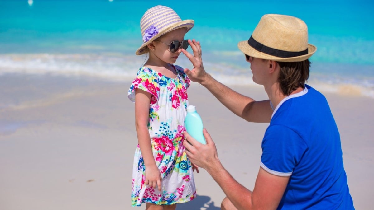 Photo of a father putting sunscreen on his young daughter