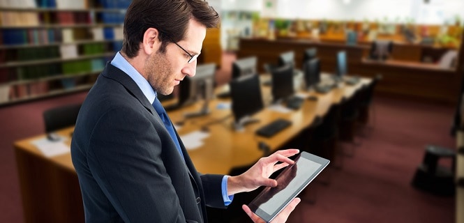 man looking at tablet in library