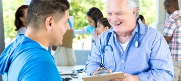 medical professional smiling and talking to man
