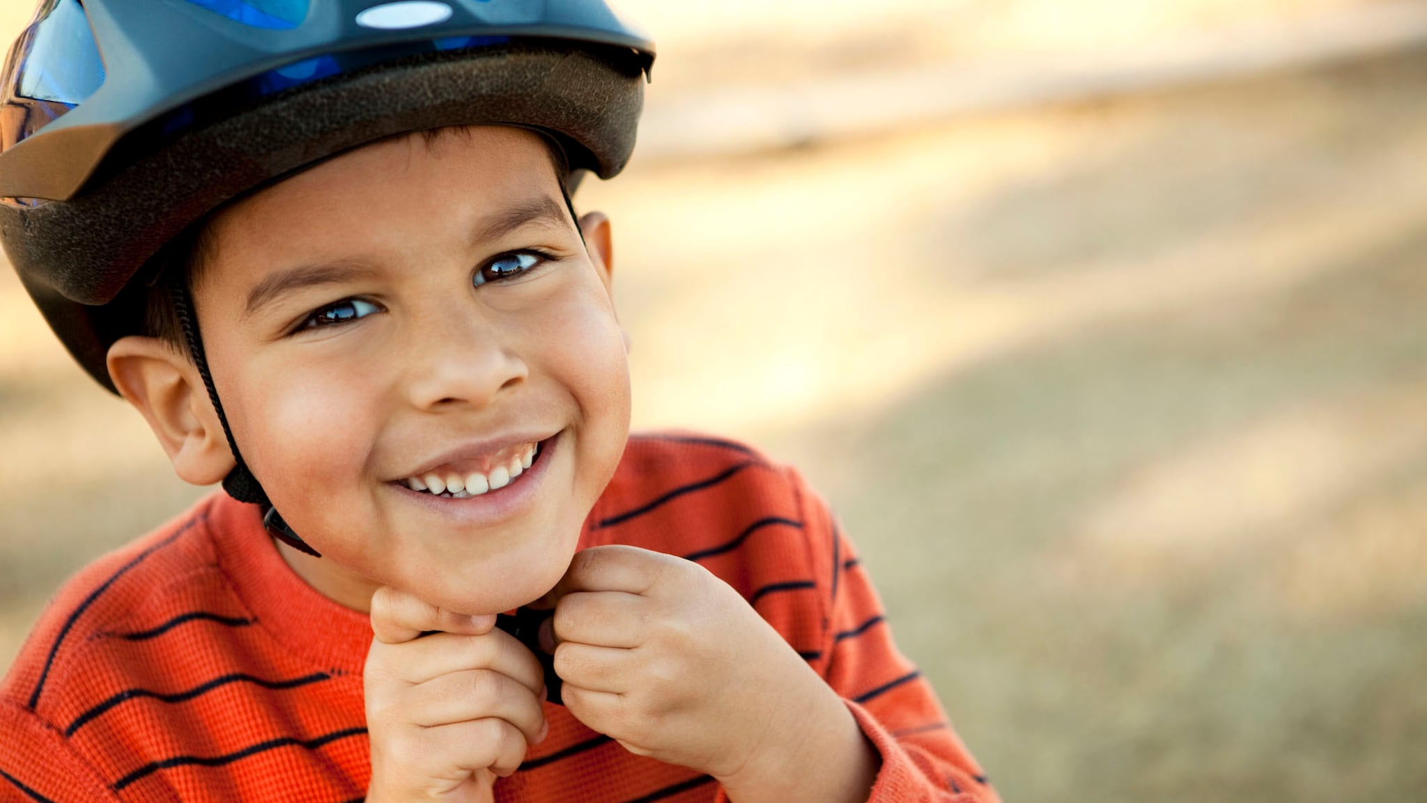 Young boy wears a bike helmet.