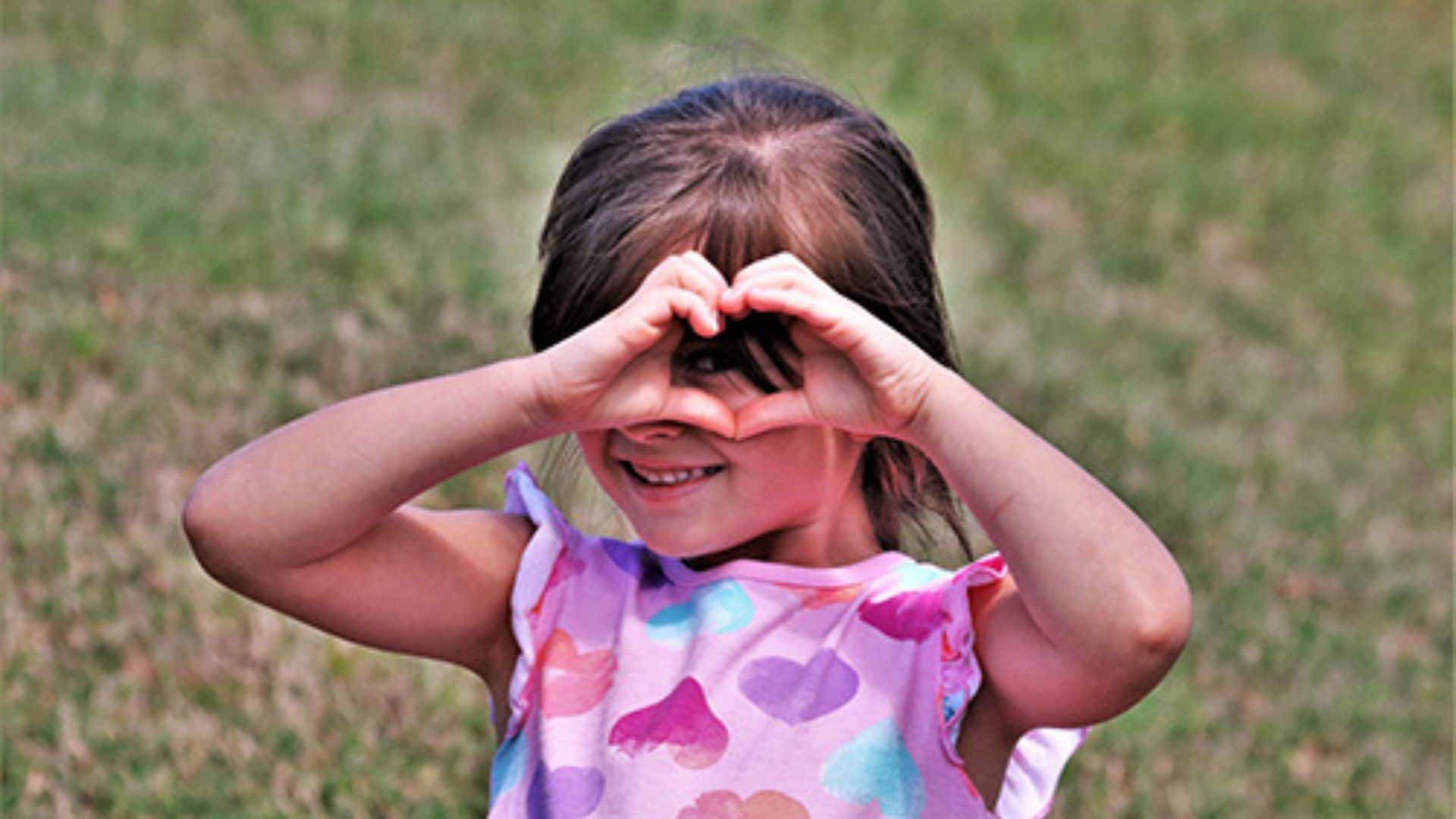 Little girl making heart gestures