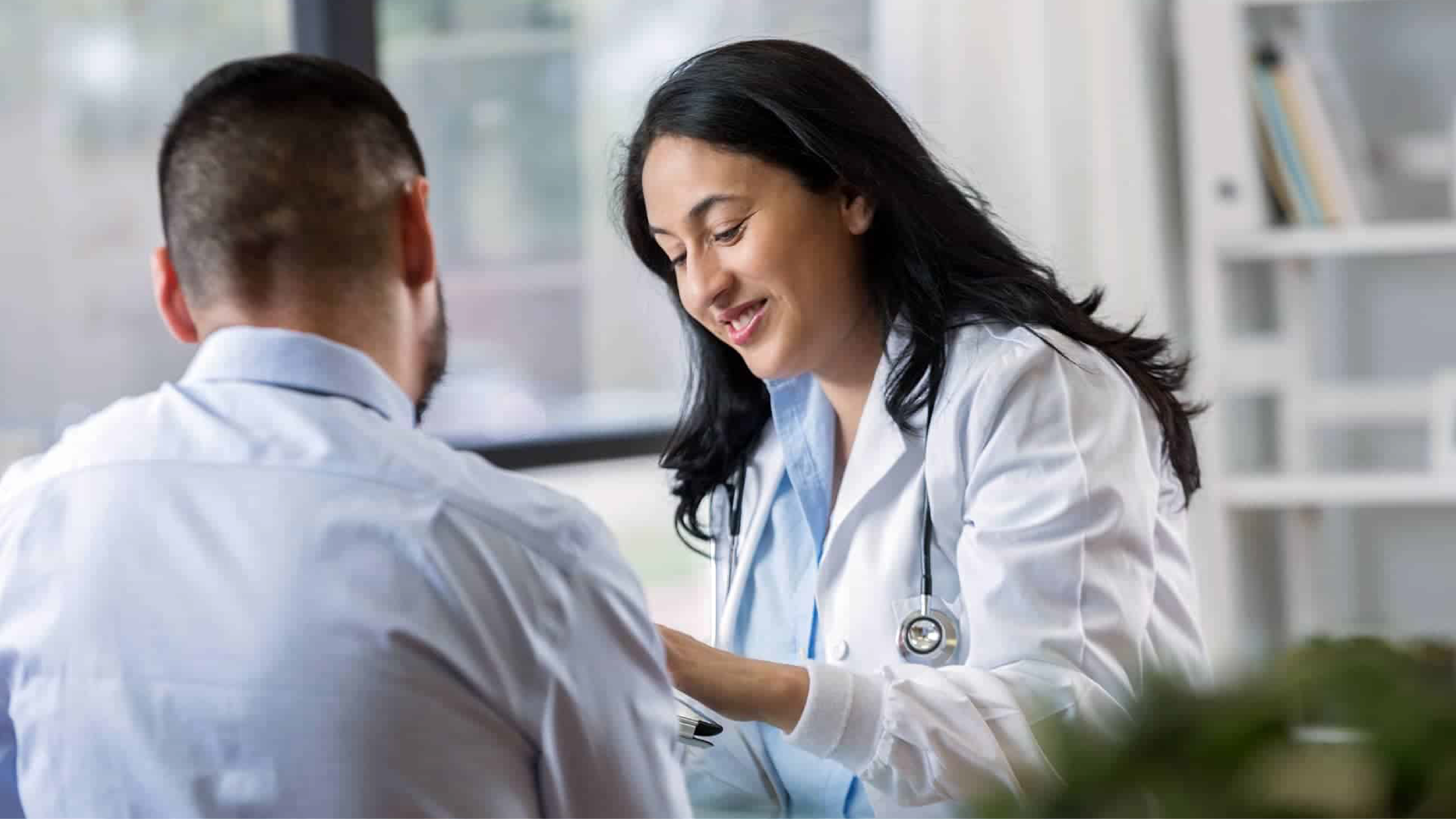 A health care provider talking to a patient. Both are looking at something the provider is holding.