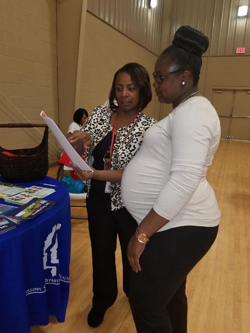 Lisa Moore, Community Health Director for District 1 (left) provides Zika prevention information during the Grenada Health Summit on April 1, 2017. 