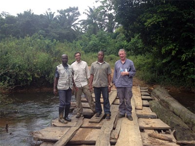 Jose and his WHO and County Health Department colleagues standing on a bridge they had to reconstruct in order to communicate with nearby villages. (Left to right: Augustine Newray (Liberian Ministry of Health and Social Welfare), Jose (CDC EISO), Wilmot Smith (Rivercess County Health Team), and Jarlath Tunney (WHO).)