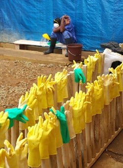 A staff member rests outside an Ebola treatment unit.