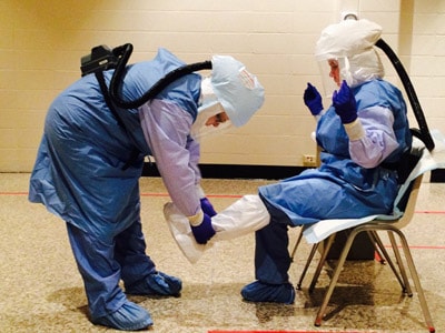 Healthcare workers practice providing care for a patient with Ebola in a mock scenario.