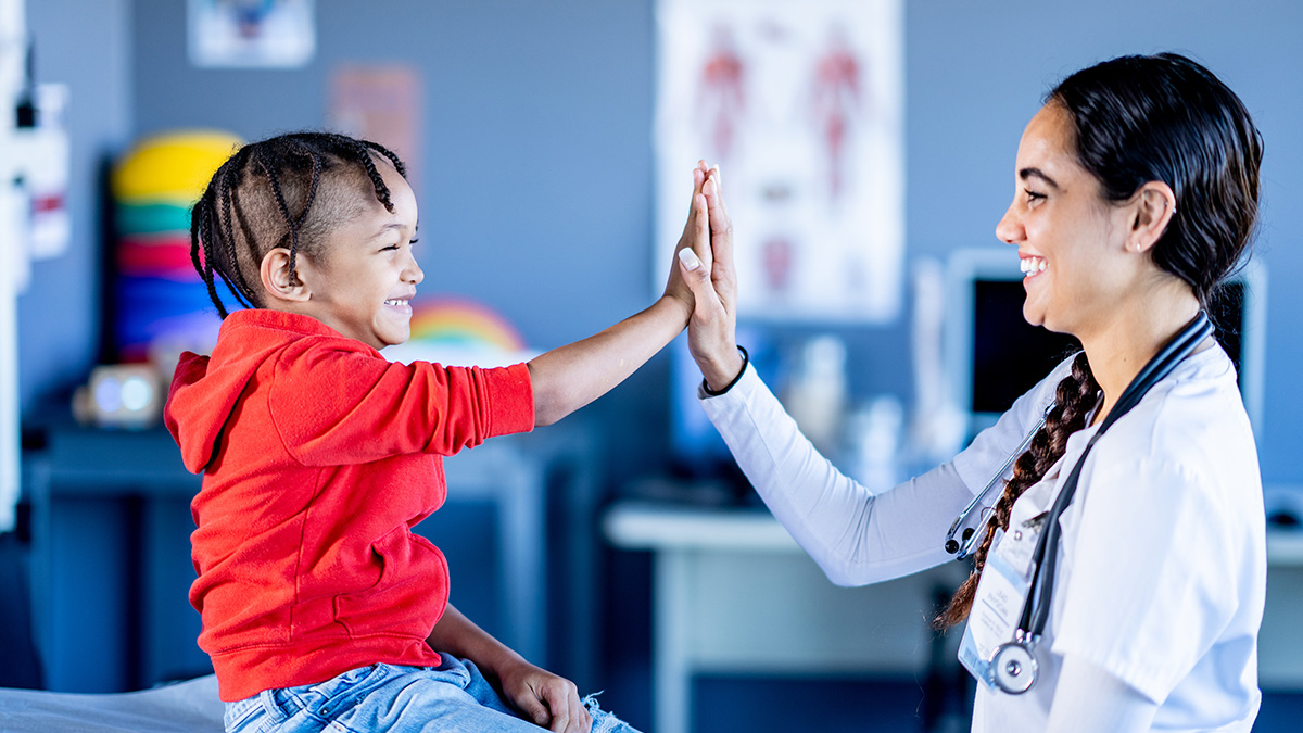 Doctor gives a high five to a toddler.