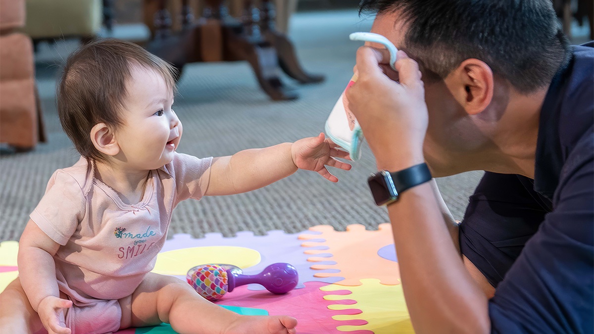 Dad playing peek-a-boo with baby.