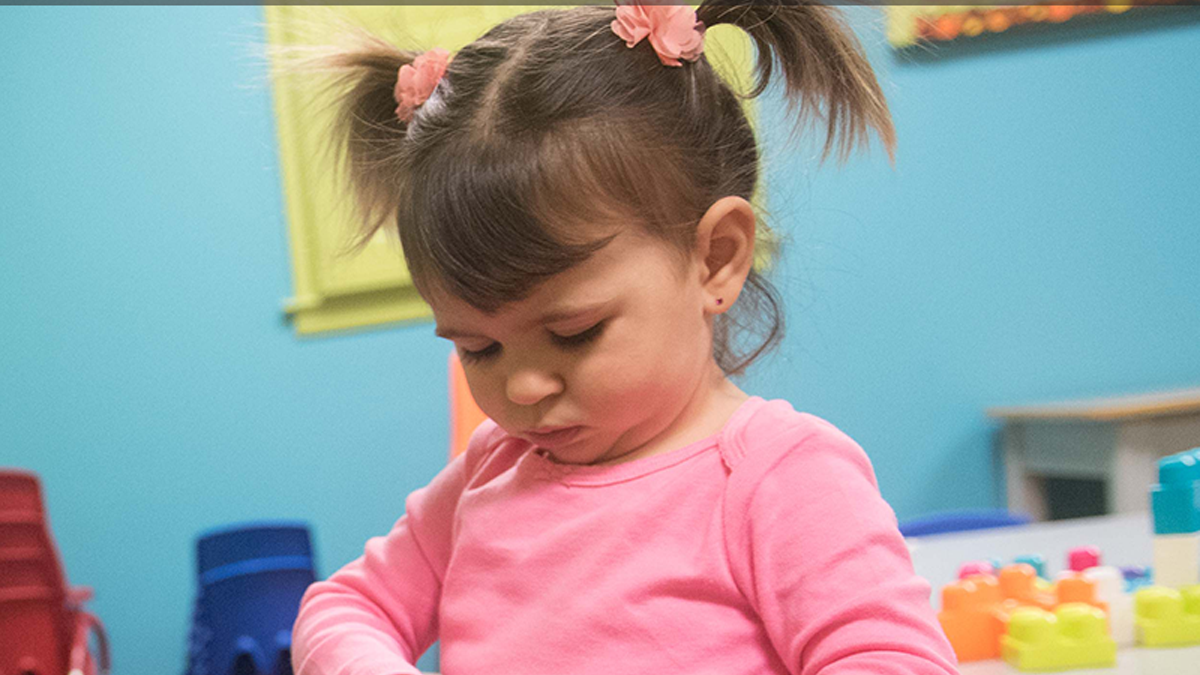 30 month old girl playing with bottle