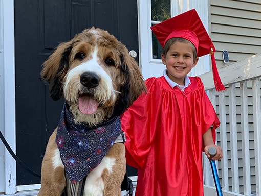 Noah in his graduation gown with his dog George