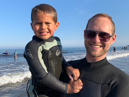 Noah and his dad pose on the beach